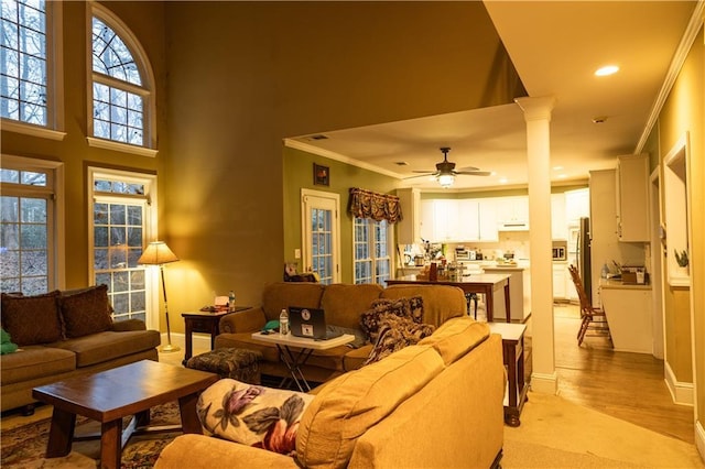 living area with baseboards, ceiling fan, crown molding, ornate columns, and recessed lighting