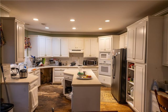 kitchen with stainless steel appliances, tasteful backsplash, light countertops, and under cabinet range hood