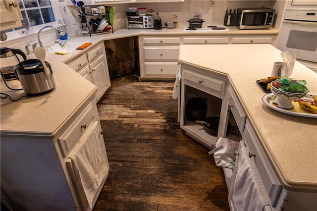 kitchen with light countertops, white appliances, a sink, and decorative backsplash