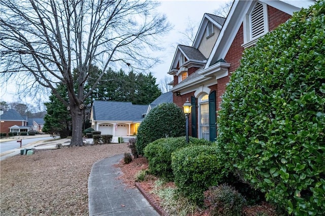 view of side of property with a garage and brick siding