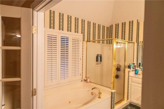 full bath featuring a garden tub, a shower stall, and wallpapered walls