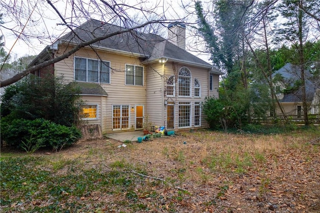 rear view of property featuring a chimney