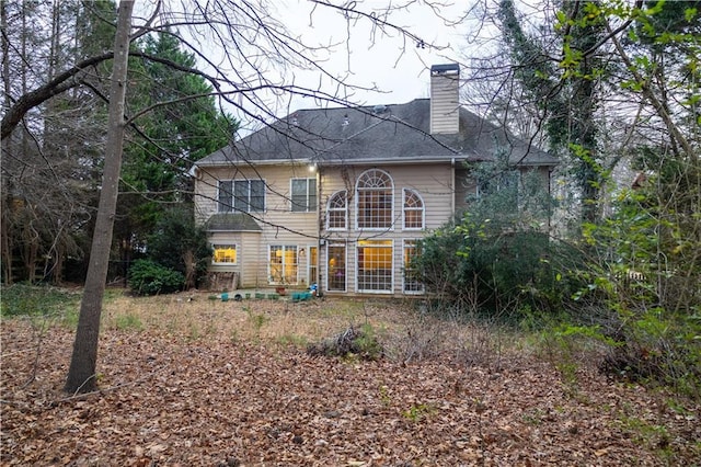 rear view of house featuring a chimney