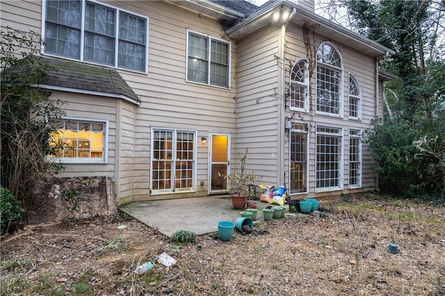 rear view of property featuring a patio and a chimney