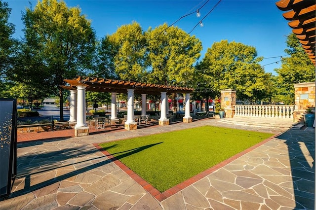 view of property's community featuring a pergola and a patio