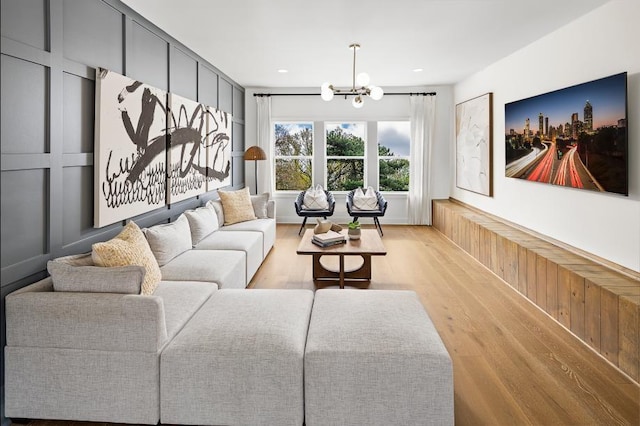 living area featuring light wood-style floors, a chandelier, and recessed lighting