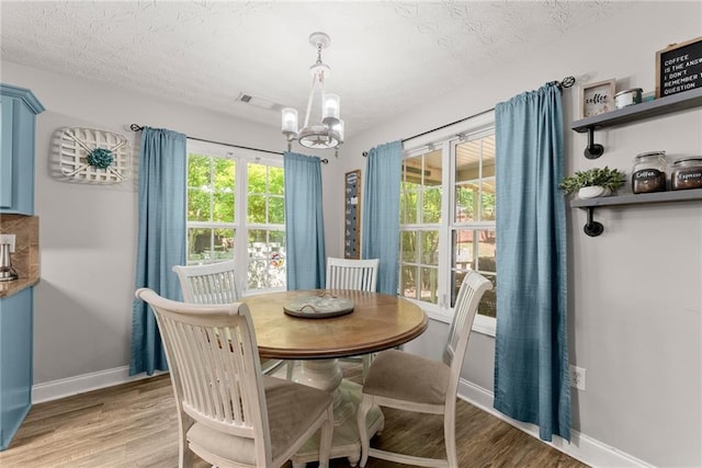 1338 Jefferson Station Rd, Jefferson, GA 30549 - dining area with a textured ceiling, visible vents, baseboards, light wood finished floors, and an inviting chandelier