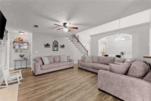 1338 Jefferson Station Rd, Jefferson, GA 30549 - living room featuring arched walkways, a textured ceiling, ceiling fan with notable chandelier, light wood-type flooring, and visible vents