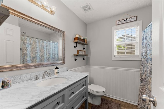 1338 Jefferson Station Rd, Jefferson, GA 30549 - full bathroom featuring vanity, toilet, a wainscoted wall, wood finished floors, and visible vents