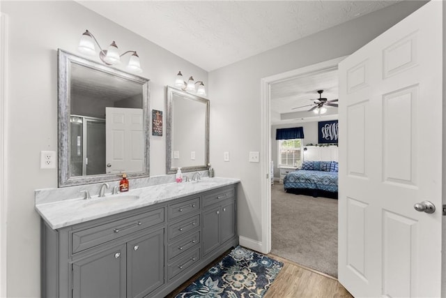 1338 Jefferson Station Rd, Jefferson, GA 30549 - ensuite bathroom with double vanity, a ceiling fan, wood finished floors, a textured ceiling, and a sink
