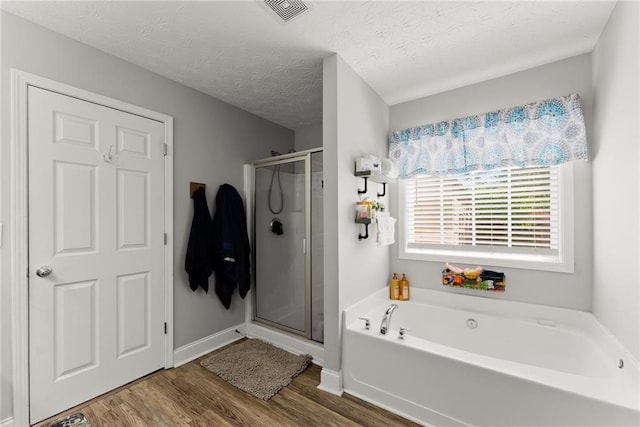 1338 Jefferson Station Rd, Jefferson, GA 30549 - full bathroom with a textured ceiling, wood finished floors, visible vents, a garden tub, and a stall shower
