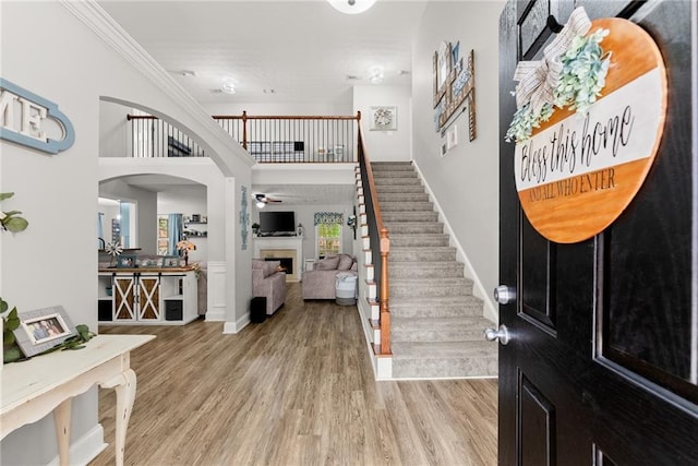 1338 Jefferson Station Rd, Jefferson, GA 30549 - entrance foyer featuring ornamental molding, stairs, wood finished floors, ceiling fan, and a lit fireplace