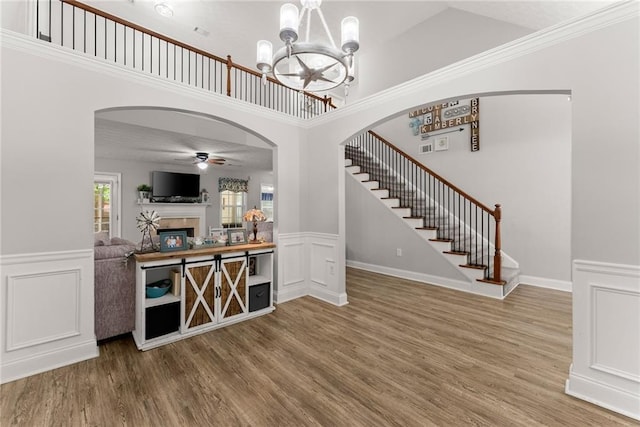 1338 Jefferson Station Rd, Jefferson, GA 30549 - interior space featuring wood finished floors, stairway, a wainscoted wall, arched walkways, and ceiling fan with notable chandelier