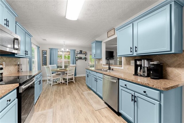 1338 Jefferson Station Rd, Jefferson, GA 30549 - kitchen featuring backsplash, blue cabinets, appliances with stainless steel finishes, a sink, and light wood-style flooring