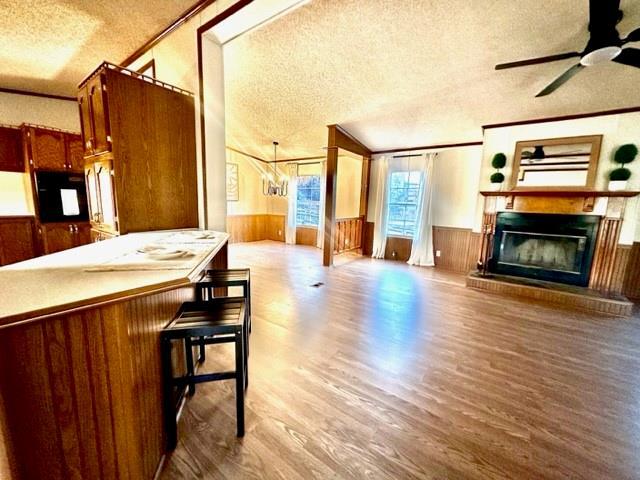 kitchen featuring a glass covered fireplace, a textured ceiling, and wainscoting