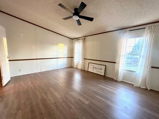 unfurnished living room featuring a wealth of natural light, crown molding, lofted ceiling, and wood finished floors