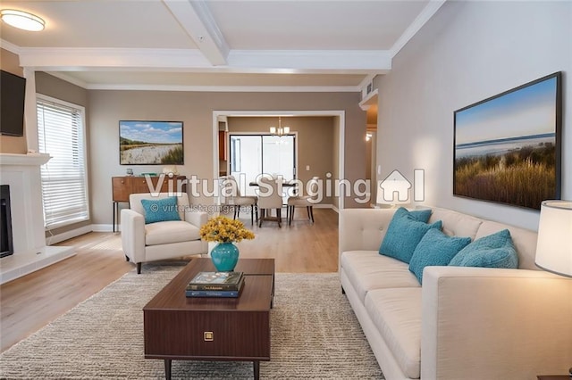 living room with a fireplace with raised hearth, wood finished floors, baseboards, ornamental molding, and beamed ceiling