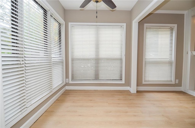 unfurnished dining area featuring light wood-type flooring, ceiling fan, and baseboards