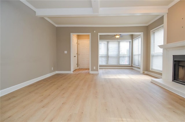 unfurnished living room featuring light wood finished floors, baseboards, a fireplace with raised hearth, and ornamental molding