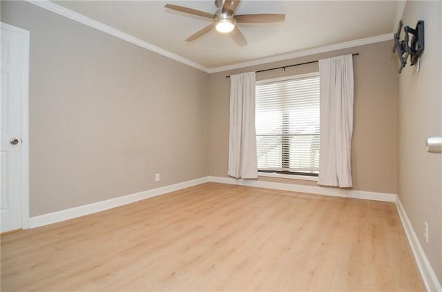 spare room with baseboards, light wood finished floors, and crown molding