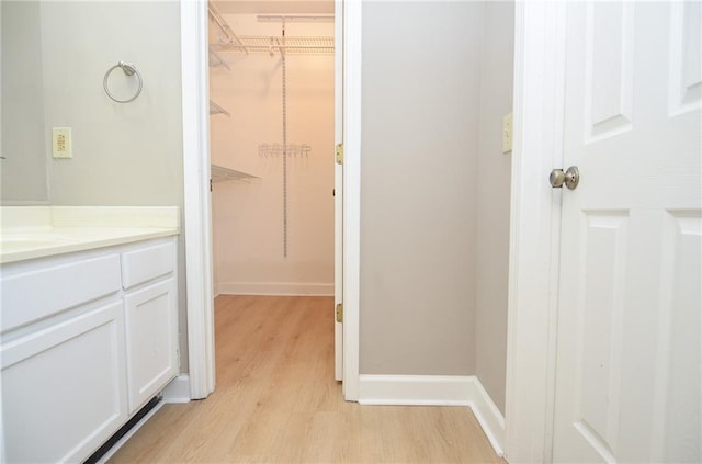 interior space with baseboards, wood finished floors, and vanity