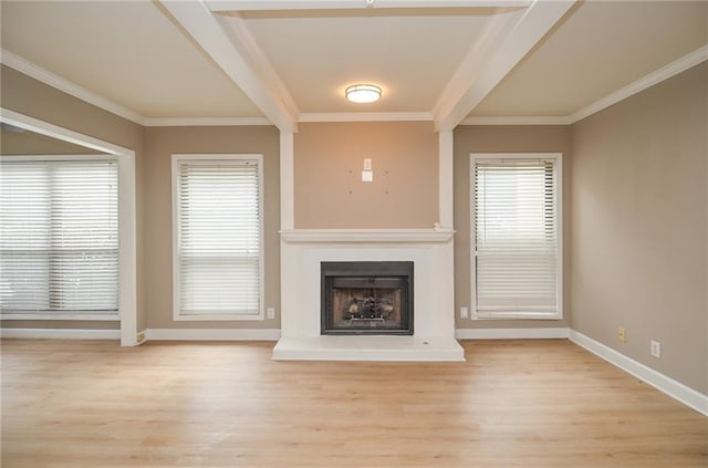 unfurnished living room featuring light wood-style floors, a healthy amount of sunlight, a fireplace with raised hearth, and crown molding