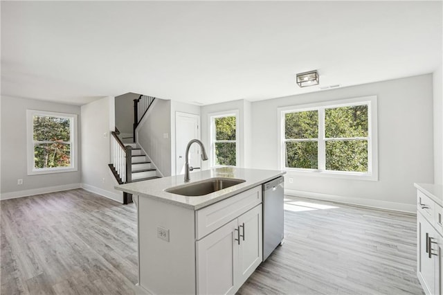 6075 Quail Mountain Trl, Gainesville, GA 30506 - kitchen featuring a sink, stainless steel dishwasher, light wood finished floors, baseboards, and a center island with sink