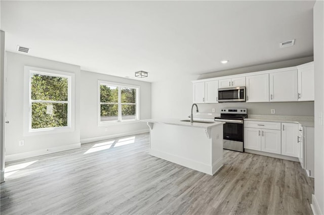 6075 Quail Mountain Trl, Gainesville, GA 30506 - kitchen featuring stainless steel appliances, light countertops, a sink, light wood-type flooring, and white cabinetry
