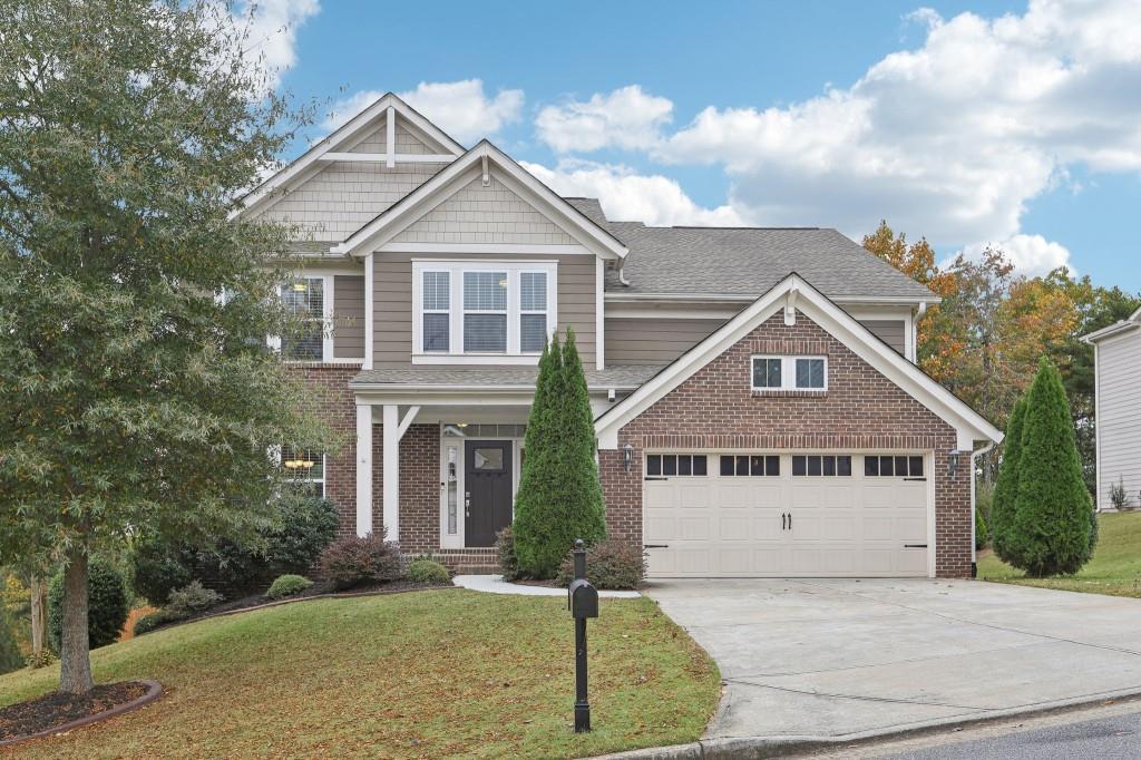 craftsman inspired home with a garage and a front yard