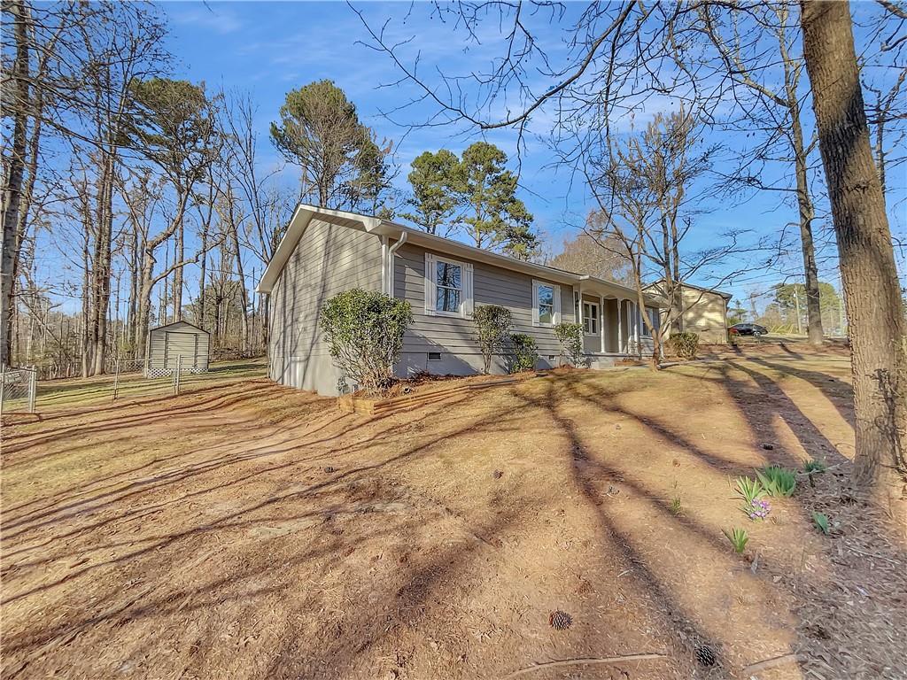 view of front facade with an outbuilding, crawl space, and dirt driveway