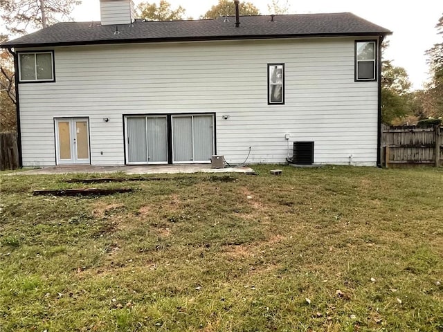 rear view of property featuring french doors, a yard, a patio, and central AC unit