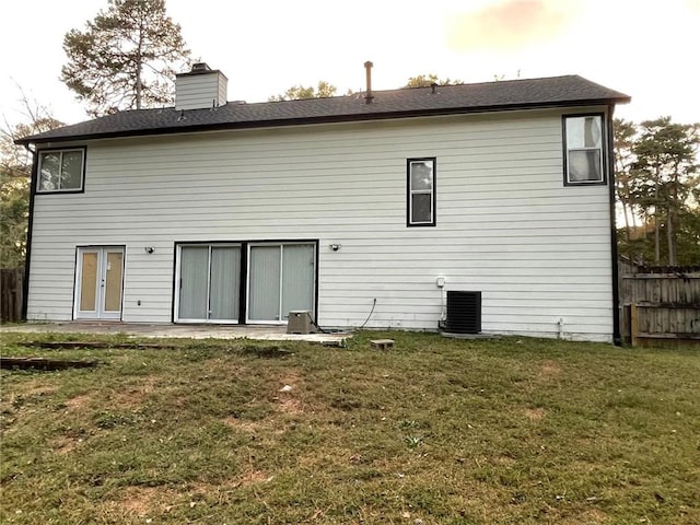 rear view of house featuring a patio area, a yard, and central air condition unit