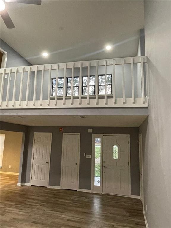 foyer entrance with ceiling fan, dark hardwood / wood-style flooring, and a towering ceiling