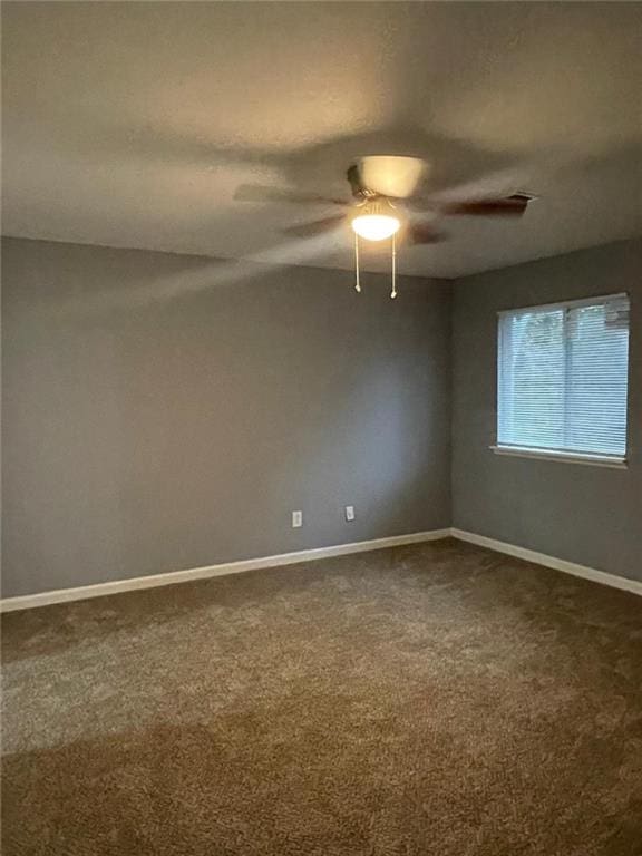 spare room featuring carpet floors, vaulted ceiling, and ceiling fan