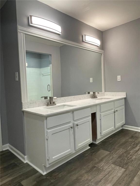 bathroom featuring hardwood / wood-style floors, vanity, and a shower