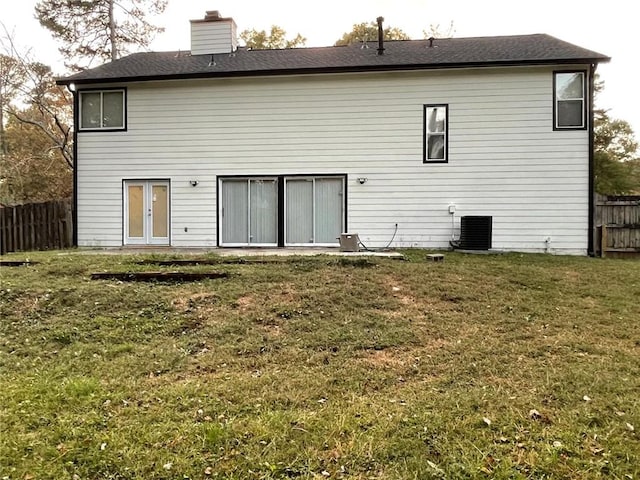 back of property featuring french doors, a yard, and cooling unit