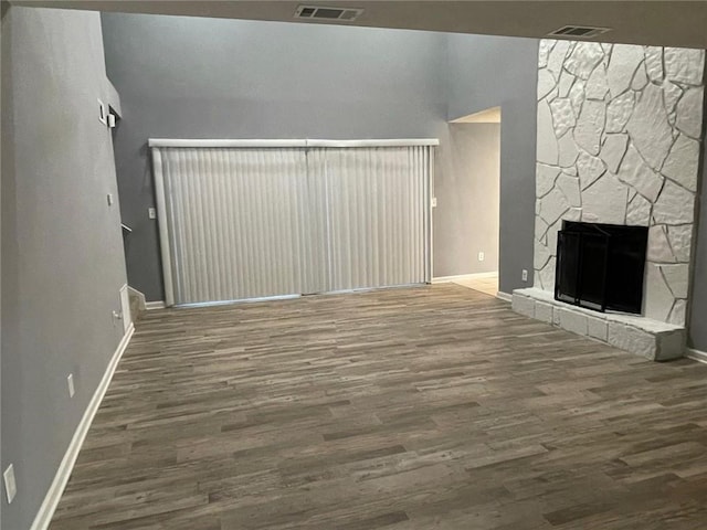 unfurnished living room featuring a stone fireplace and hardwood / wood-style flooring