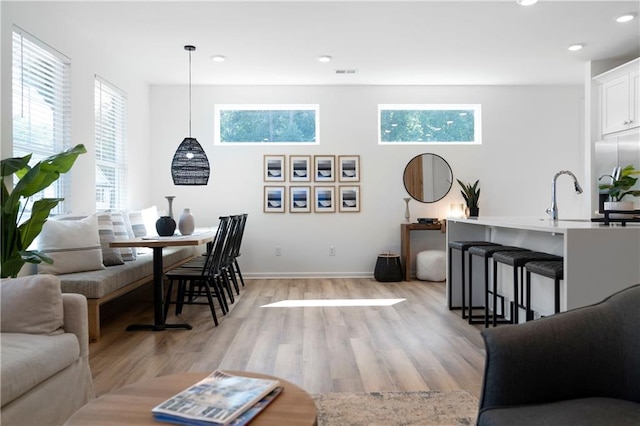 living room featuring light wood-type flooring and sink