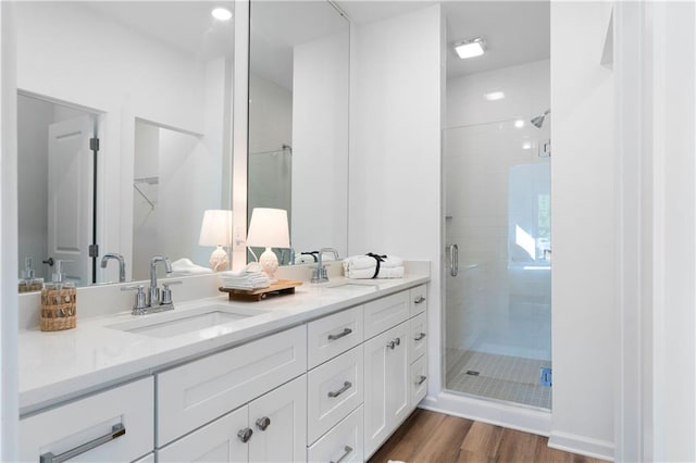 bathroom featuring vanity, a shower with shower door, and wood-type flooring