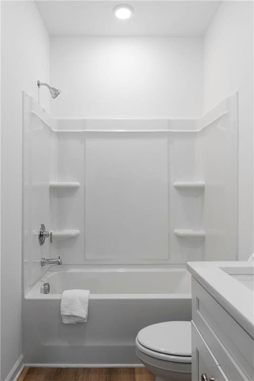 full bathroom featuring washtub / shower combination, vanity, wood-type flooring, and toilet