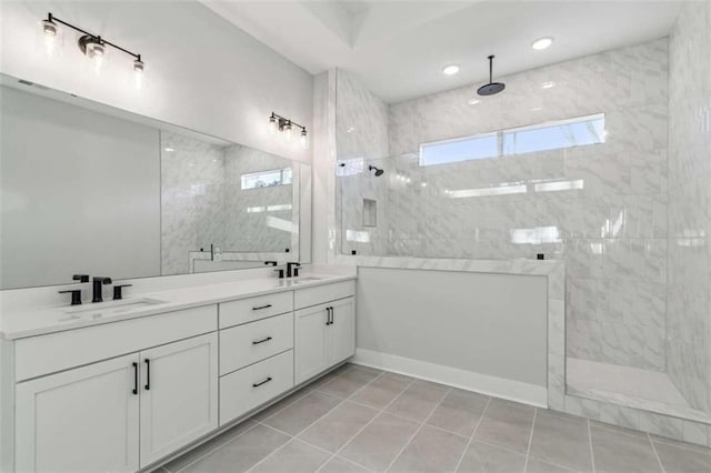 bathroom featuring tile patterned floors, walk in shower, a sink, and double vanity