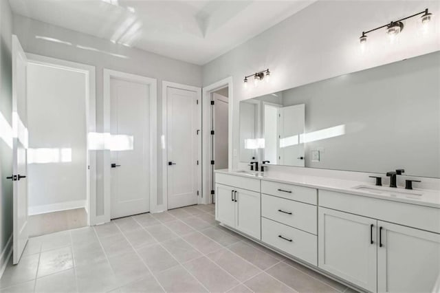 full bath with double vanity, tile patterned flooring, and a sink