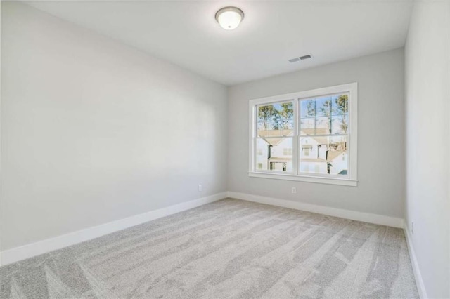 unfurnished room featuring carpet, visible vents, and baseboards