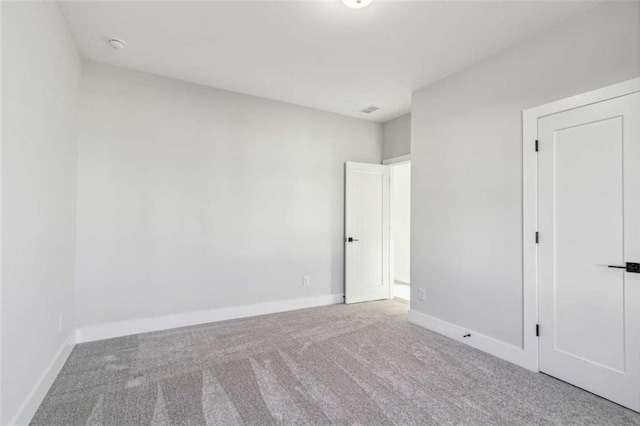 carpeted empty room featuring baseboards