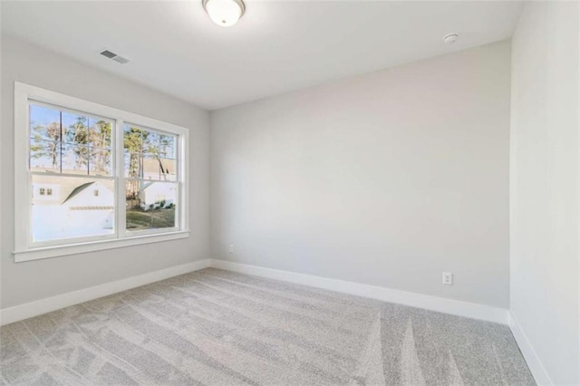 empty room with baseboards, visible vents, and carpet
