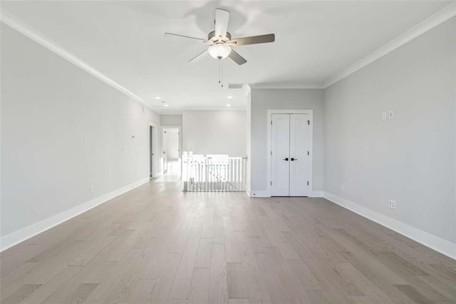 unfurnished room with a ceiling fan, crown molding, wood finished floors, baseboards, and visible vents