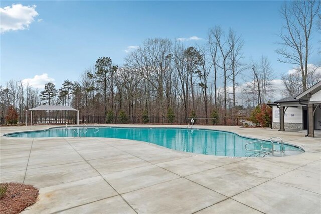 community pool featuring a patio area and fence