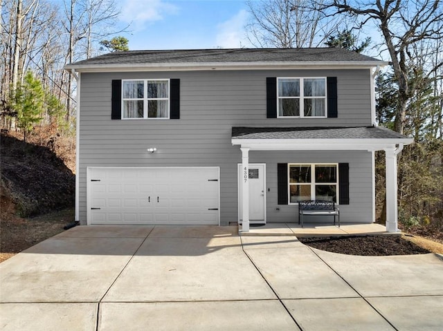 traditional-style house with covered porch, roof with shingles, driveway, and an attached garage