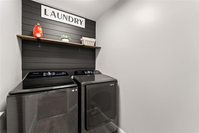 clothes washing area with washing machine and dryer, laundry area, and baseboards