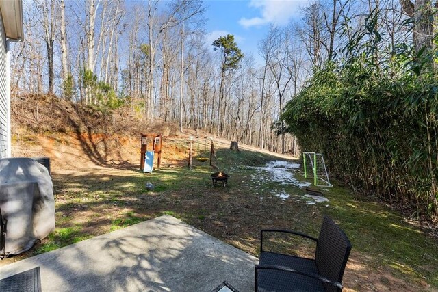 back of house with cooling unit, a playground, an outdoor fire pit, and a patio area